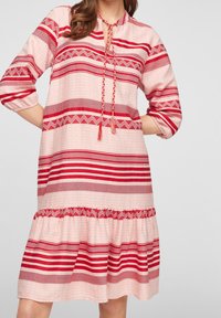 Rood en roze gestreepte jurk met driekwartmouwen, een ronde halslijn, gevlochten koordjes en een gerimpelde zoom in laagjes. Voorzien van geometrische patronen.