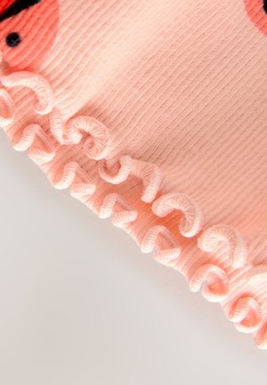 Rosa geripptes Stoffmaterial mit einem gerafften Saum. Dezente Textur und Muster mit abgerundeten Akzenten entlang des Randes.