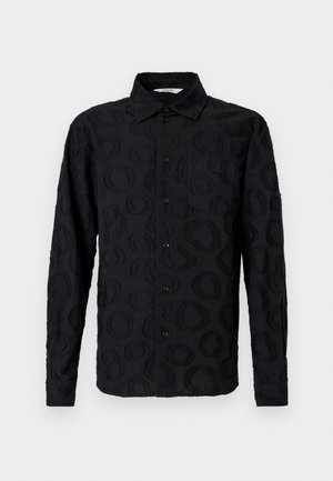 Must mustriga nööpidega särk, millel on peen tekstiilne ringikujuline muster ja rinna tasku, esitatud valgel taustal.