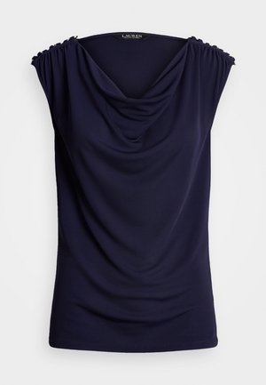 Granatowa bluzka bez rękawów z drapowanym dekoltem w kształcie kołnierza typu komin oraz marszczonymi ramionami zdobionymi małymi złotymi guzikami.