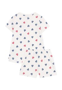 Ensemble de pyjama en coton avec un fond blanc orné de motifs de cœurs rayés rouges et bleus éparpillés. Comprend un haut à manches courtes et un short.