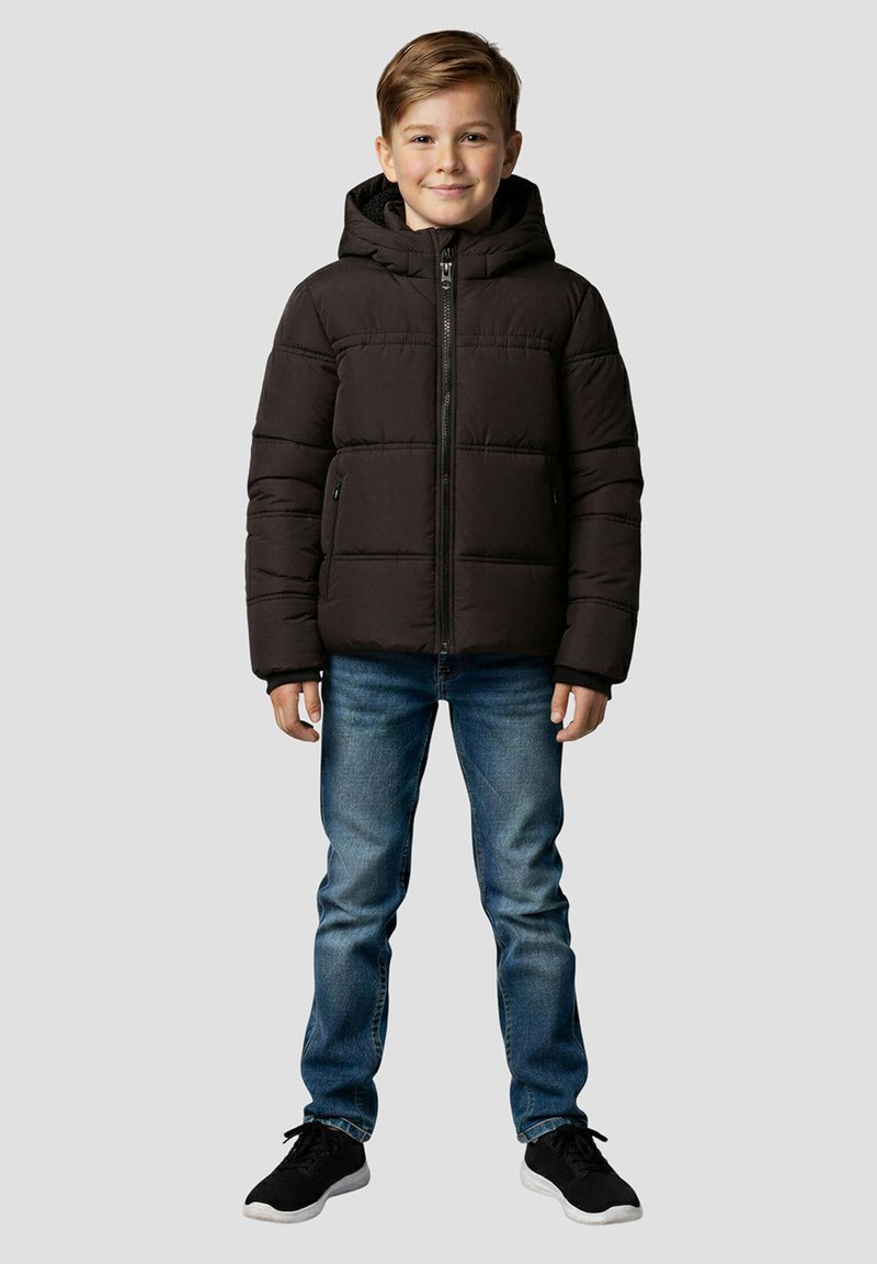 Sort puffervest med hætte, quiltet design, lynlås foran og to sidelommer, båret over blå jeans og sorte sneakers.