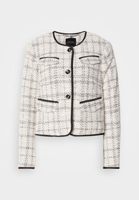 Veste pour femme en tweed blanc et noir avec col rond, quatre boutons noirs, poches à rabat décoratives, ourlée de passepoils noirs.