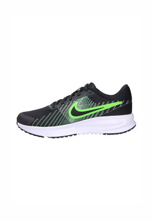Black running shoe with green accents, mesh upper, textured design, cushioned white midsole, and black rubber outsole featuring grip patterns.