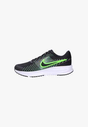 Black running shoe with green accents, mesh upper, textured design, cushioned white midsole, and black rubber outsole featuring grip patterns.