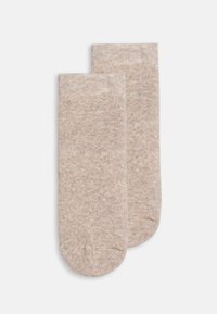 Calze lunghe fino al ginocchio in un leggero color beige, realizzate in un morbido materiale testurizzato con un sottile motivo melangiato e punta e tallone rinforzati.