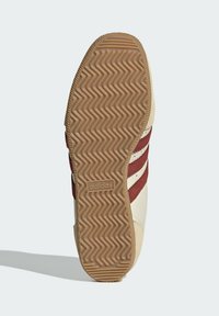 Adidas tenisica sa potplatom u riblju kost. Ima krem gornji sloj, bordo pruge i akcent logotipa. Teksturirana guma za prianjanje.