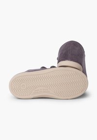 Purple corduroy shoe with a textured surface, featuring a cream rubber sole with a wavy pattern and "Made in Spain" inscription.