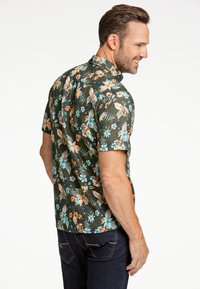 Camicia a maniche corte in tessuto verde scuro con motivo floreale, caratterizzata da fiori arancioni e blu, colletto e veste rilassata.
