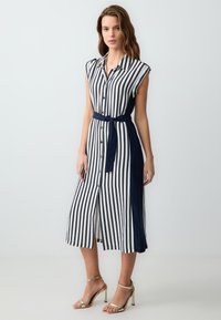 Gestreiftes Hemdblusenkleid in Blau und Weiß, mit taillierter Taille, kurzen Ärmeln und midi-langer Schnittform. Der Stoff wirkt leicht und glatt.