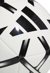 Balón de fútbol blanco con patrones geométricos negros y acentos brillantes. Diseño cosido con una textura suave en la superficie.