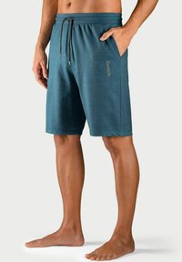 Teal sportieve shorts van zacht materiaal hebben een elastische tailleband met een trekkoord en zijzakken, met het "Bench" logo.