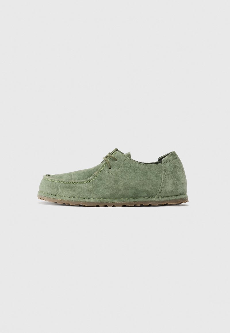 Chaussure décontractée pour homme en daim vert avec lacets, semelle en caoutchouc plate, couture style mocassin et bout arrondi, vue de profil.