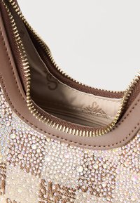 Καφέ τσάντα υφασμάτινη από πάνω με χρυστό φερμουάρ, διακοσμημένη με πυκνό μοτίβο μικρών ιριδίζοντων στρας και κεντημένες λεπτομέρειες.