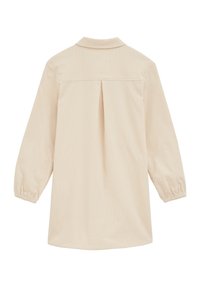 Camicia a maniche lunghe color crema con colletto, dettagli con plissettature sul retro e polsini elasticizzati. Texture liscia con motivo a costine verticali.
