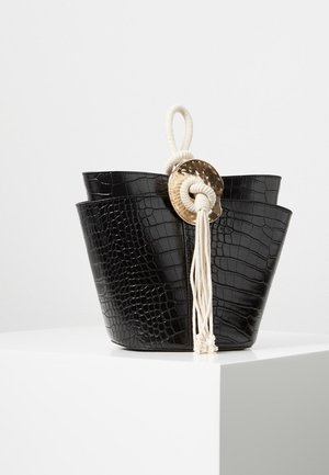 Czarna torba typu bucket z teksturowanej ekoskóry, z szerokim otwarciem, kremowymi rączkami z liny oraz okrągłym złotym akcentem.