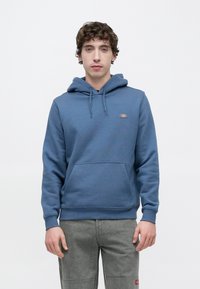 Μπλε βαμβακερό φούτερ με κουκούλα, τσέπη καγκουρό, ρυθμιζόμενη κουκούλα με κορδόνι, ribbed μανσέτες και λογότυπο στο στήθος.