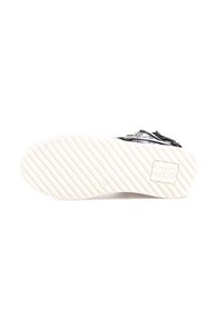 Zwarte leren schoen met een gestructureerd oppervlak en decoratieve accenten. Witte rubberen zool met een geribbeld patroon, merk "AS 98."