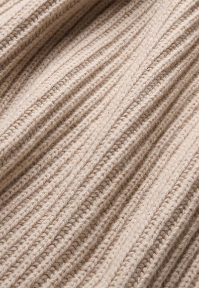 Beige gebreide stof met een verticaal ribpatroon, met een zachte textuur en natuurlijke vezels, wat een warme, gezellige uitstraling creëert.