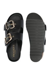 Zwarte slide-sandalen met dubbele gespsluitingen, een bovenwerk van soepel leer en een geribbelde rubberen zool voor grip. Maatlabel aan de binnenkant.