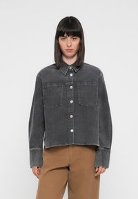 Gray denim jacket with a collared neck, front button closure, and two chest pockets. Features long sleeves and a cropped design.
