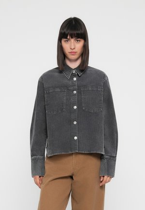 Giubbotto in denim grigio con colletto, chiusura frontale con bottoni e due tasche sul petto. Presenta maniche lunghe e un design accorciato.