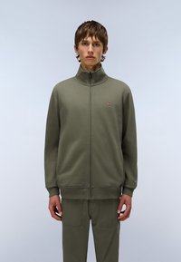 Sudadera con cremallera de color verde oliva y cuello alto, con puños y cinturilla acanalados, que presenta un pequeño logo en el lado izquierdo del pecho. Textura de tela suave.