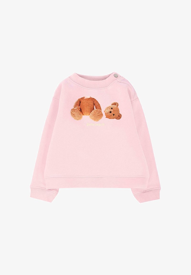 Sweatshirt rose avec un col rond et des manches longues. Présente un graphique en peluche texturé d'ours et le nom de la marque "Palm Angels" en jaune.