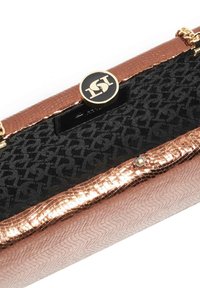 Rose gold clutch bag with a textured surface, black fabric lining, and a circular logo closure. Features a patterned interior.