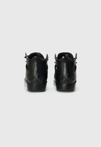 Baskets montantes en cuir noir avec une finition lisse, présentant un logo discret, un col rembourré et une semelle extérieure translucide.
