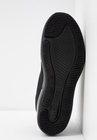 Sola di scarpa sportiva nera con gomma testurizzata, scanalature per trazione e un prominente logo "AIR MAX". Bordo liscio e curvato.