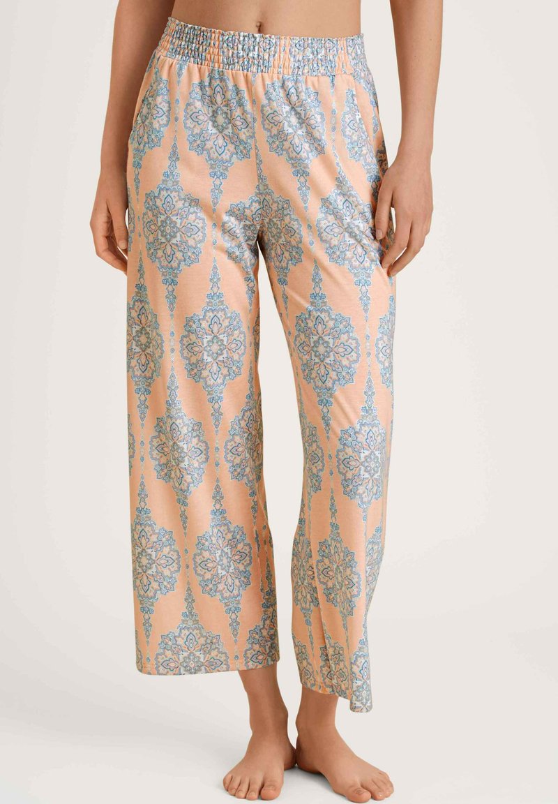 Lichte, perzikkleurige pyjamabroek met een blauw damastpatroon, wijde pijpen en een smockband voor comfort.