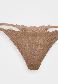 Brune blonde truse med blomster- og hjerte-mønster, med doble sidebånd og en bølget blonde livlinje.