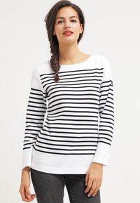 Stribet langærmet bluse i hvid og sort med vandrette striber, rund halsudskæring og afslappet pasform. Stoffet virker blødt og glat.