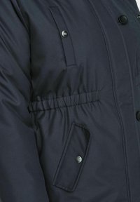 Granatowa kurtka puchowa z wcięciem w talii, dużą klapką na kieszeń i zatrzaskami. Wykonana z wytrzymałego materiału o gładkiej fakturze.