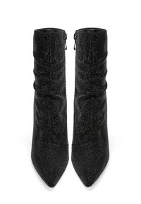 Un paio di stivali alti neri con tacco, dotati di piccole borchie scintillanti e cerniere laterali, con punte affilate e gambaletti leggermente arricciati.