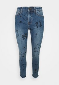 Jeans de mezclilla azul con patrones de constelaciones en negro, ajustados, de cintura media y con detalles de dobladillo deshilachado.