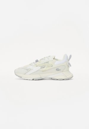 Fehér sneaker texturált felsőrésszel, fényvisszaverő részletekkel és vastag talppal. Hátsó füle és oldalfalon nyomtatott logó részlet jellemzi.