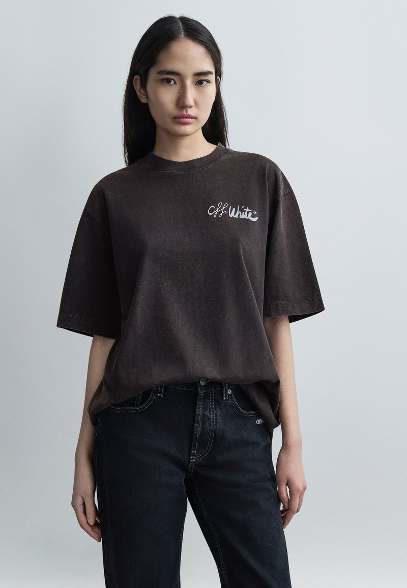 Υπερμεγέθη καφέ βαμβακερό t-shirt με στρογγυλή λαιμ όκοψη και κοντά μανίκια, με λευκό λογότυπο "Off-White" στο αριστερό στήθος. Συνδυασμένο με σκούρο τζιν.