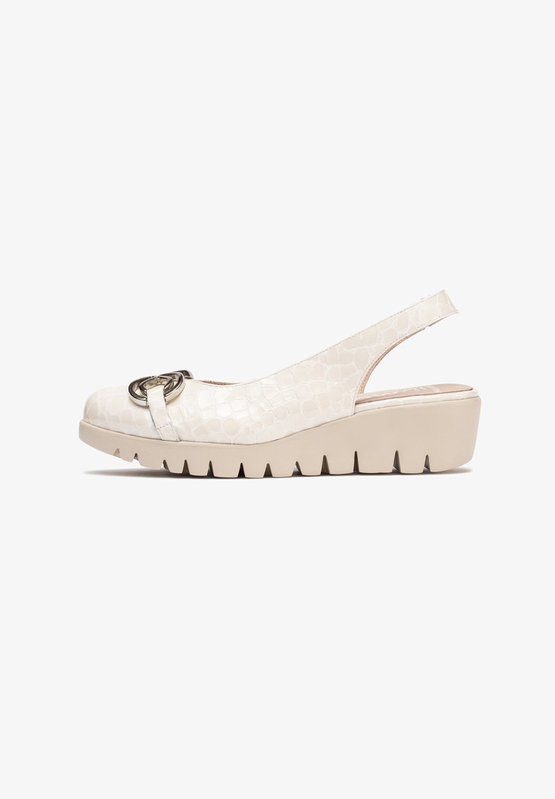 Chaussure à talon wedge à bride arrière en matériau beige texturé avec une finition lisse. Présente un accent métallique circulaire et une semelle plateforme striée.