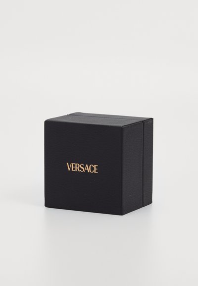 Cutie de cadou rectangulară neagră, cu o suprafață texturată, având un logo auriu "VERSACE" pe față, destinată ambalajului de lux.