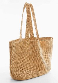 Bolso de tote de paja trenzada, color tostado, forma rectangular, con dos asas largas y parte superior abierta, que presenta un acabado texturizado y una estructura flexible.