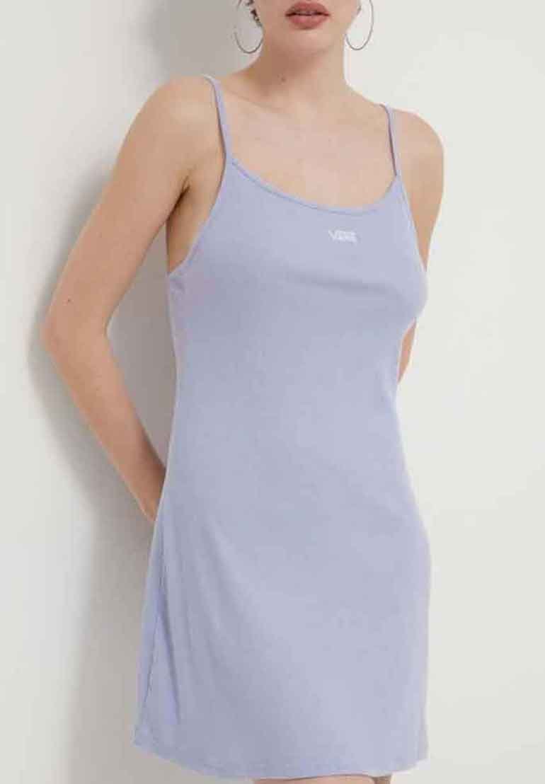 Femme portant une robe nuisette sans manches de couleur violet clair avec des bretelles fines et un petit logo blanc sur la poitrine, se tenant devant un fond uni.