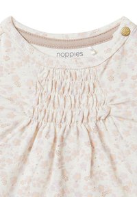 Romantische crèmekleurige top met bloemenpatroon en smocked details op de borst, met een ronde halslijn en een gouden knoopaccent. Zachte, gestructureerde stof.