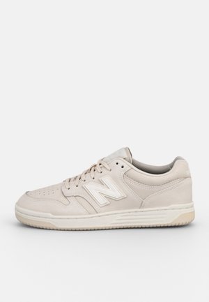 Beżowe niskie sneakersy New Balance z zapięciem na sznurówki, wyściełanym kołnierzem, perforowaną częścią na palce i teksturowaną gumową podeszwą.