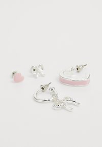Ensemble de quatre boucles d'oreilles : clous d'oreilles en argent en forme de papillon, clous d'oreilles en forme de cœur rose, et une créole avec un accent rose et un pendentif en forme de papillon.