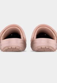 Ζευγάρι ροζ λαστιχένια σανδάλια χωρίς κορδόνια με υφασμένα πέλματα, αποτυπωμένα από πίσω σε λευκό φόντο.