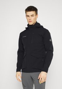 Veste noire imperméable avec une poche poitrine zippée, une capuche réglable et des poches à rabat à l'avant. Texture lisse avec des accents minimaux.