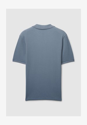 Polo bleu clair en tissu tricoté texturé, manches courtes, col classique, présentant une couleur unie partout.