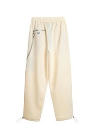 Pantalones deportivos de color beige claro con cintura elástica, bolsillo lateral con cremallera, detalle de cadena y puños ajustables. Tejido suave y ajuste relajado.